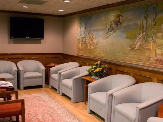 The practice's waiting room, with a painted mural above the wood panelling.