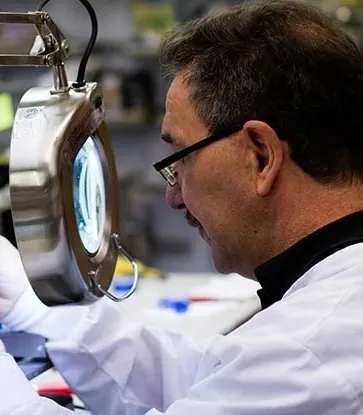 A technician at work under a magnifier in the practice's in-house laboratory.