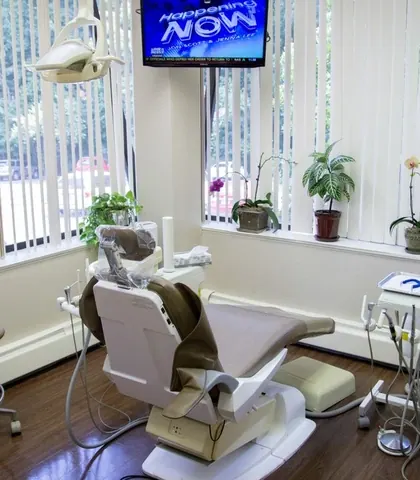 A treatment room with windows on two sides and a ceiling-mounted screen.