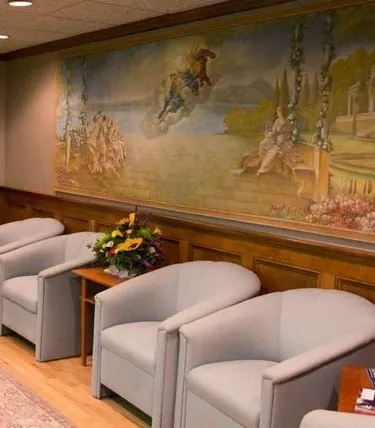 The waiting room, with a painted mural above the wood panelling.